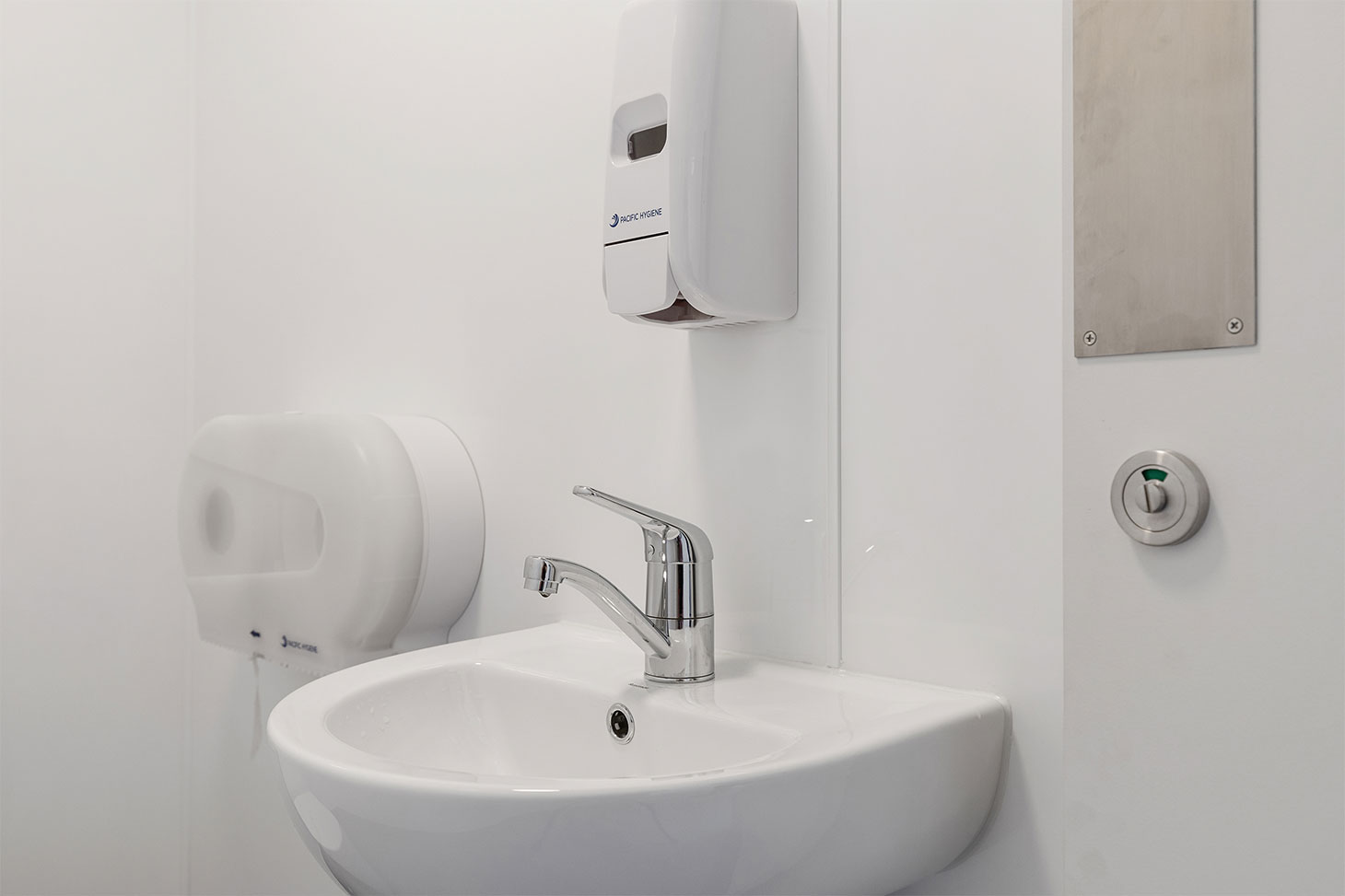 basin with sanitiser and paper towel dispenser